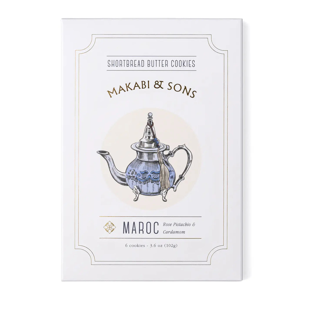 A box of Makabi & Sons Maroc Shortbread Butter Cookies, featuring an elegant illustration of a Moroccan-style teapot. The packaging highlights the rose pistachio and cardamom flavor of the cookies.