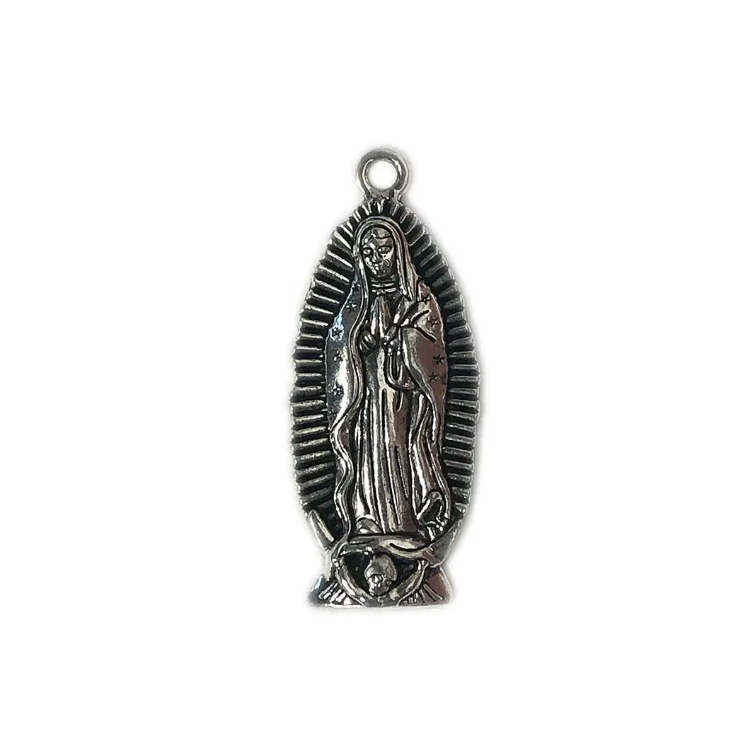 A nickel-plated brass charm depicting Our Lady of Guadalupe with intricate details, featuring a split ring hole at the top for hanging or attaching.