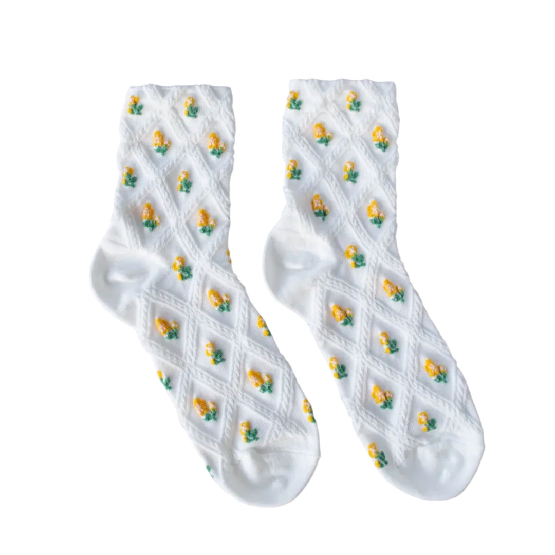 a pair of white socks featuring a delicate diamond knit pattern, each section is adorned with tiny embroidered yellow flowers.