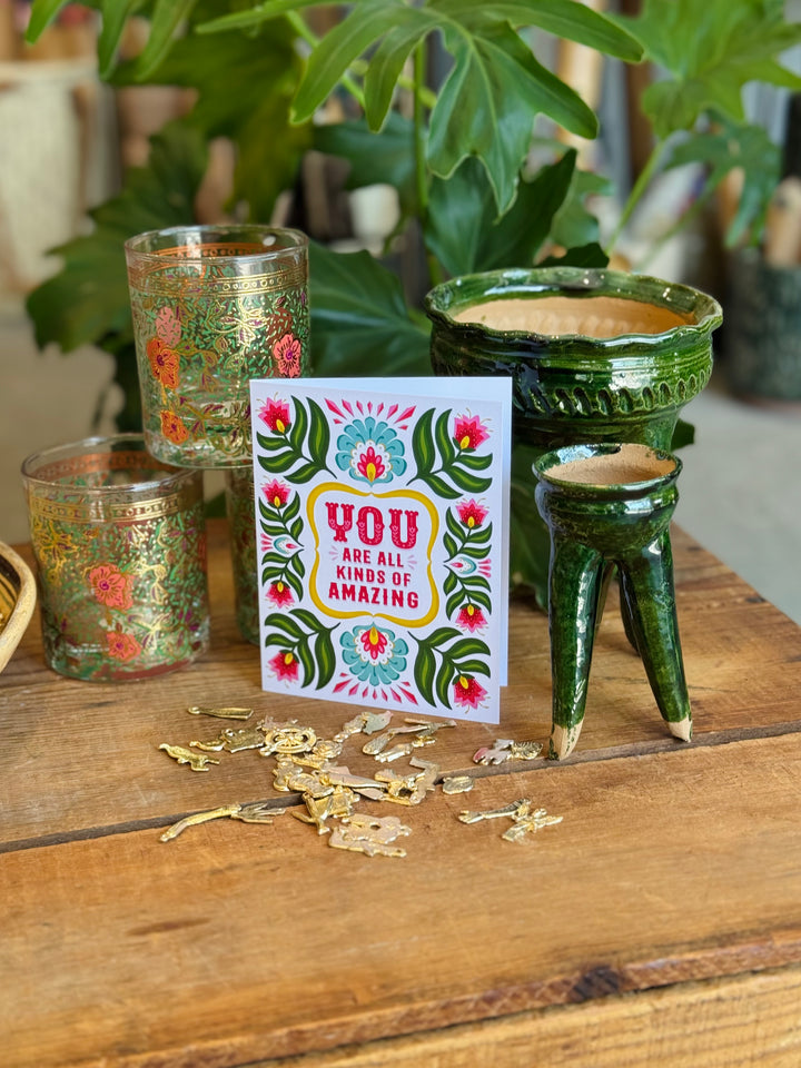 Card with floral design and text on a wooden surface with decorative items