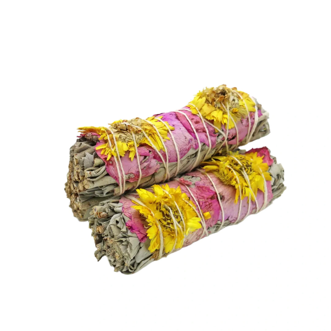 Two 4-inch bundles of white sage wrapped with pink rose petals and yellow sunflowers, tied together with natural string.