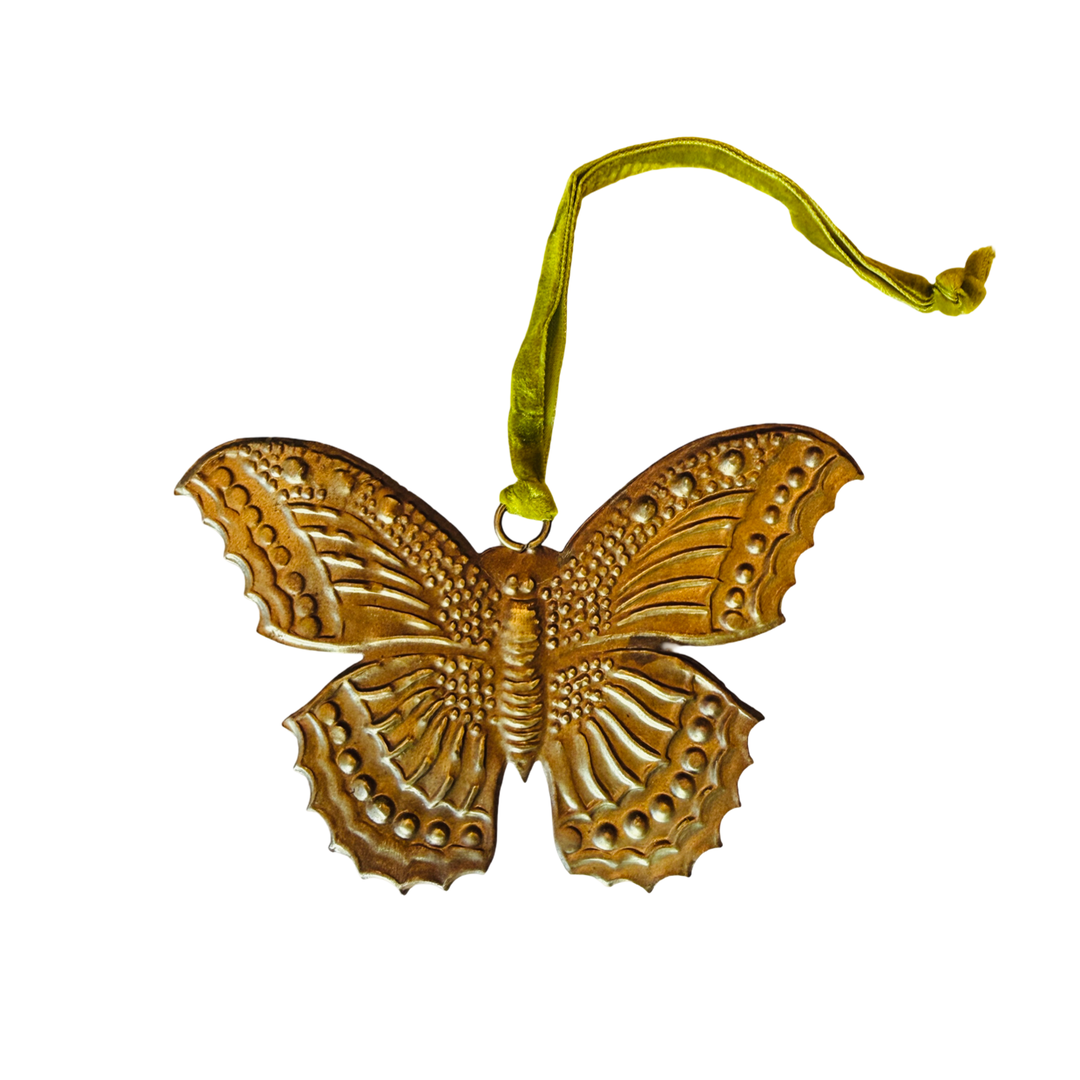 antique gold butterfly ex voto embossed with dotted and ridged detail across its scalloped wings featuring a green velvet loop.