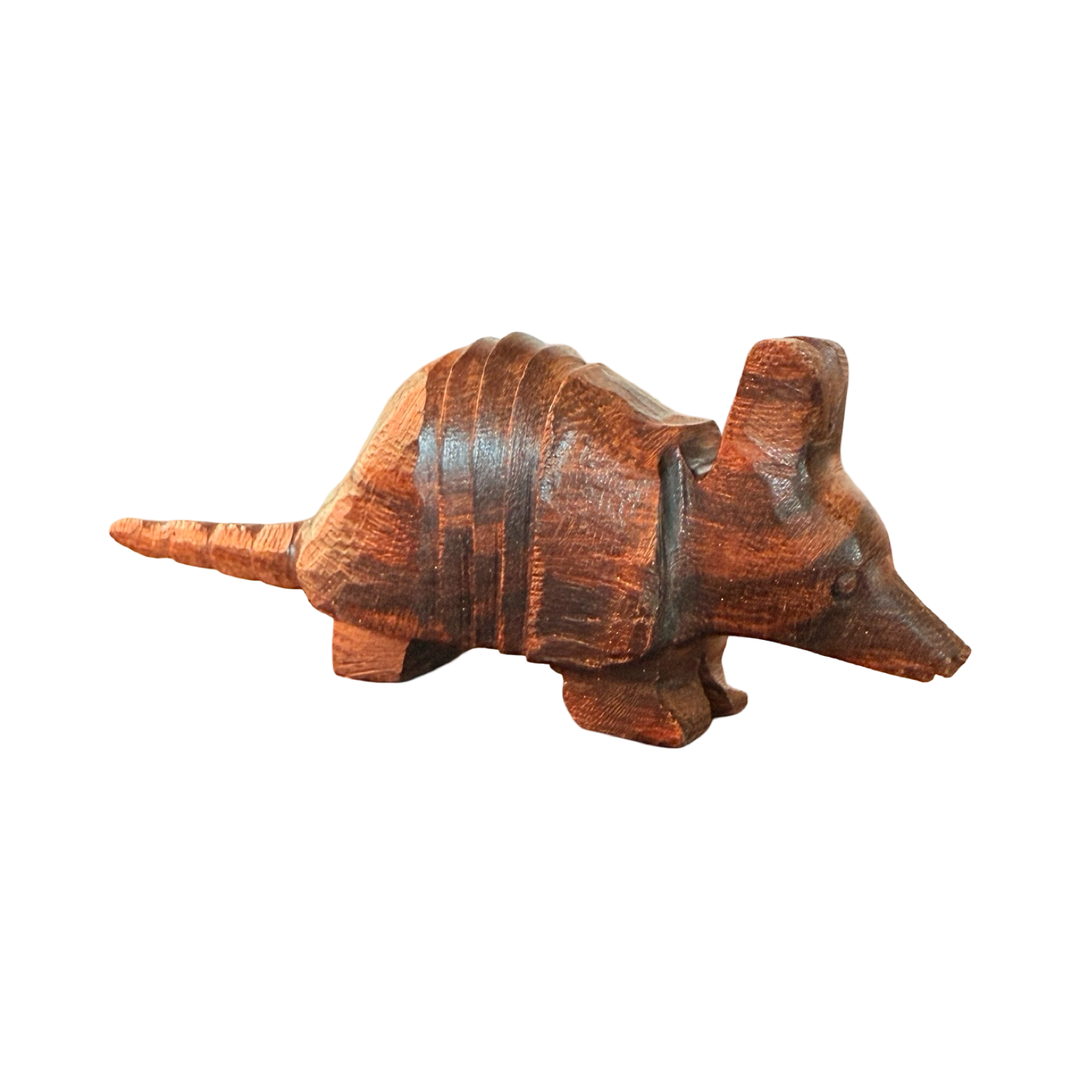 side angle view of a Handcarved wooden armadillo sculpture made from polished ironwood with natural grain variations.