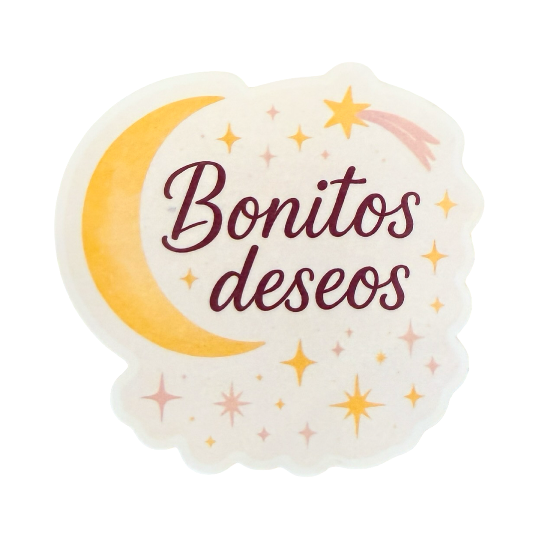 Sticker with the phrase "Bonitos deseos" in burgundy script, surrounded by a yellow crescent moon, stars, and sparkles on a soft cream background.
