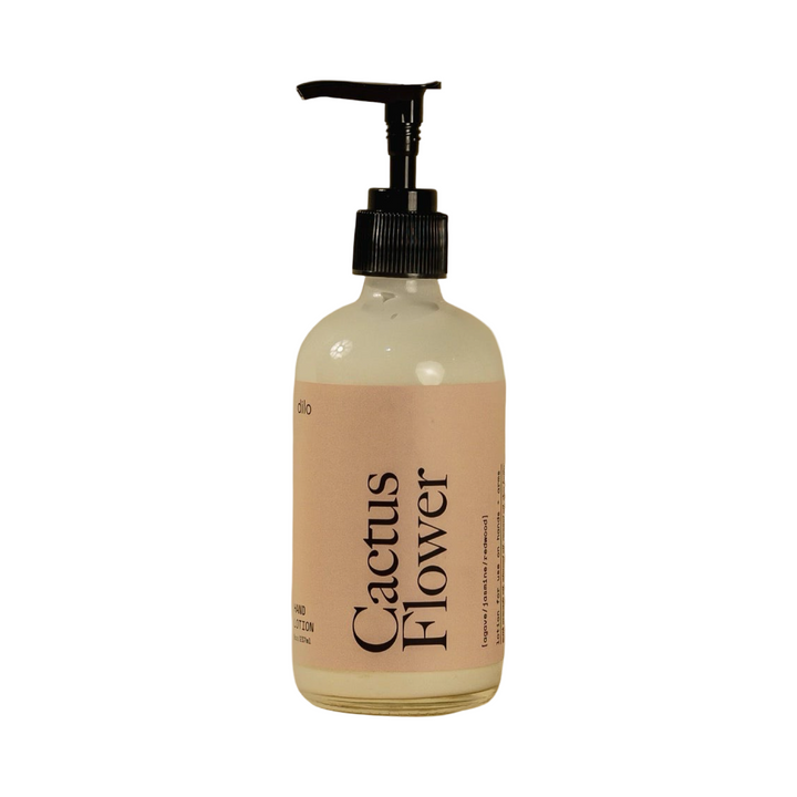 8 oz Clear glass pump bottle of Dilo Cactus Flower Hand Lotion with a soft blush pink label and bold black typography.