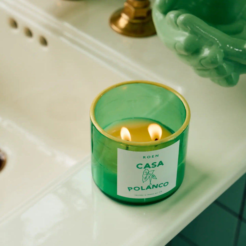 Photo of burning Casa Polanco candle in a bathroom setting.