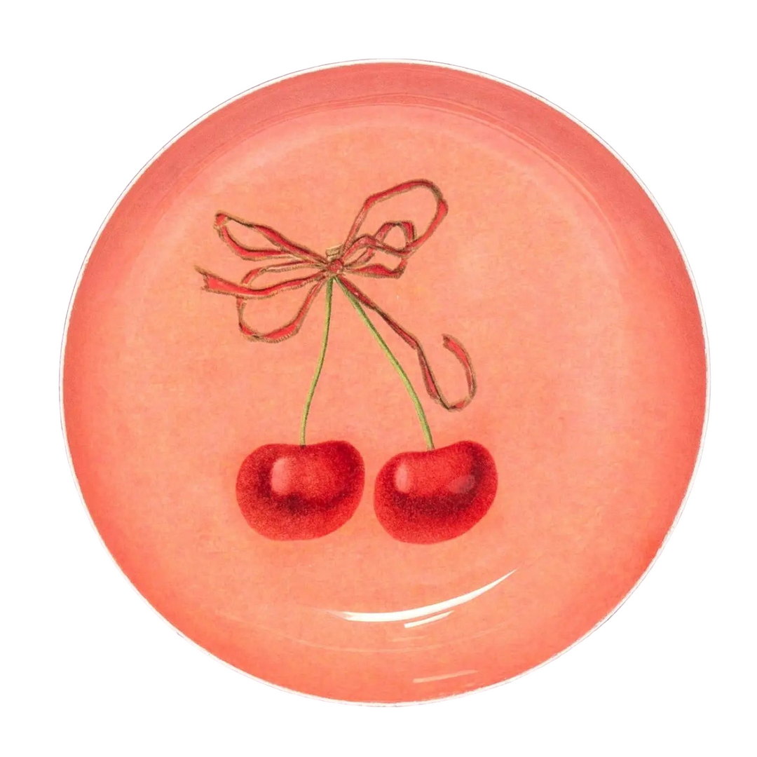 Round peach colored enamel tray with illustrated cherries tied with a ribbon.