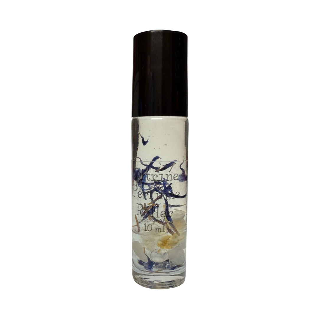 A citrine Crystal Perfume Roller in a clear glass bottle with a black cap. The bottle contains small crystals and dried flower petals infused in liquid with the product name in white lettering.