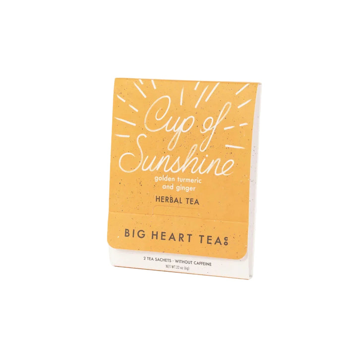 Cup of Sunshine herbal tea packet featuring golden turmeric and ginger with two tea sachets inside.