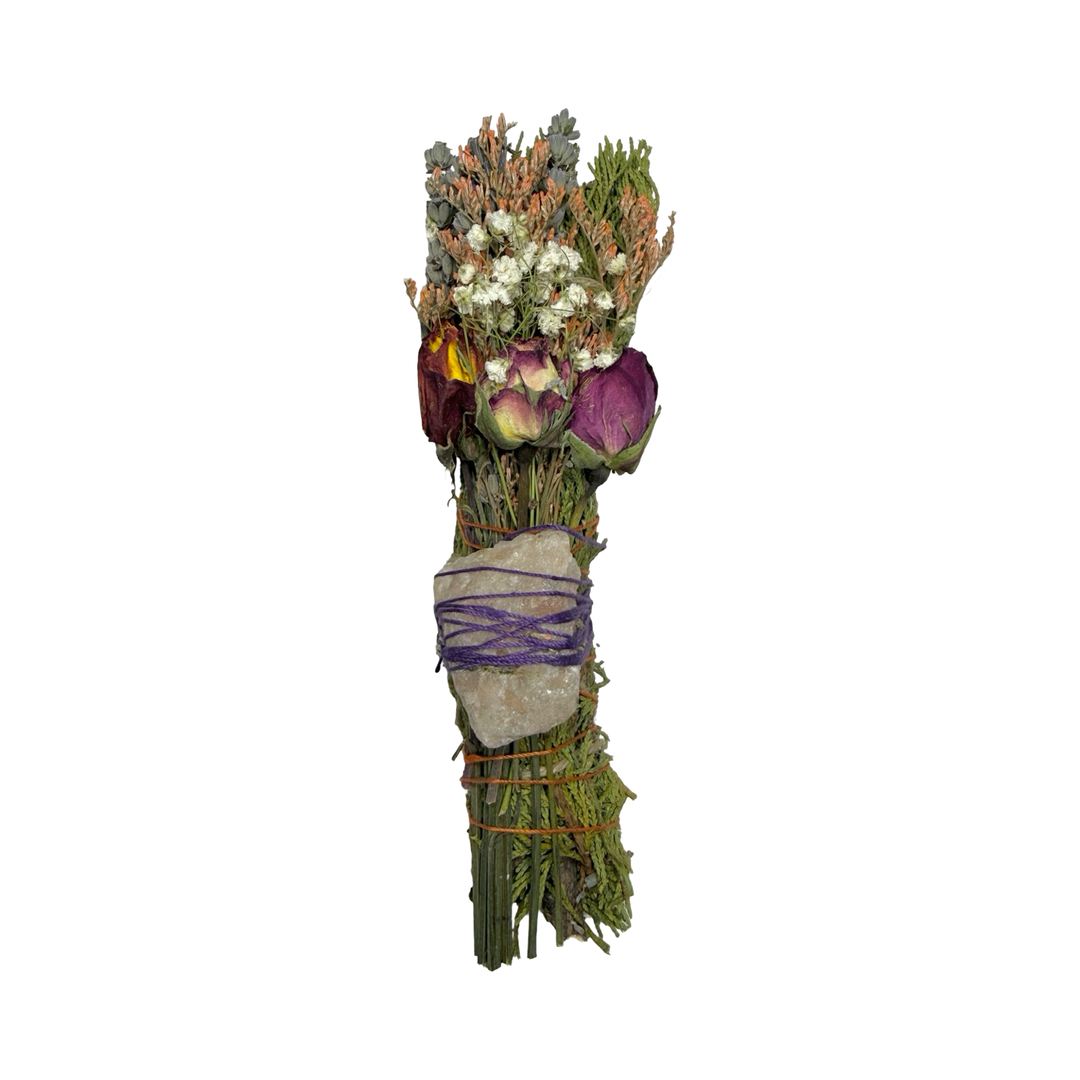 Dried herb smudge stick with roses, baby's breath, and a raw crystal wrapped in purple thread.