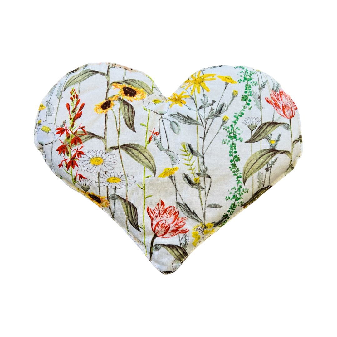 heart shaped eye pillow with a floral design on a white background