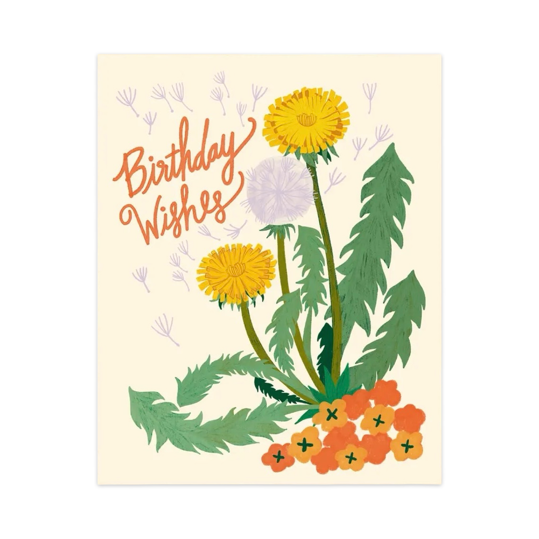 Greeting card with hand-illustrated dandelions, seed puffs, and orange flowers. The text reads “Birthday Wishes” in orange script, with a kraft envelope behind the card.