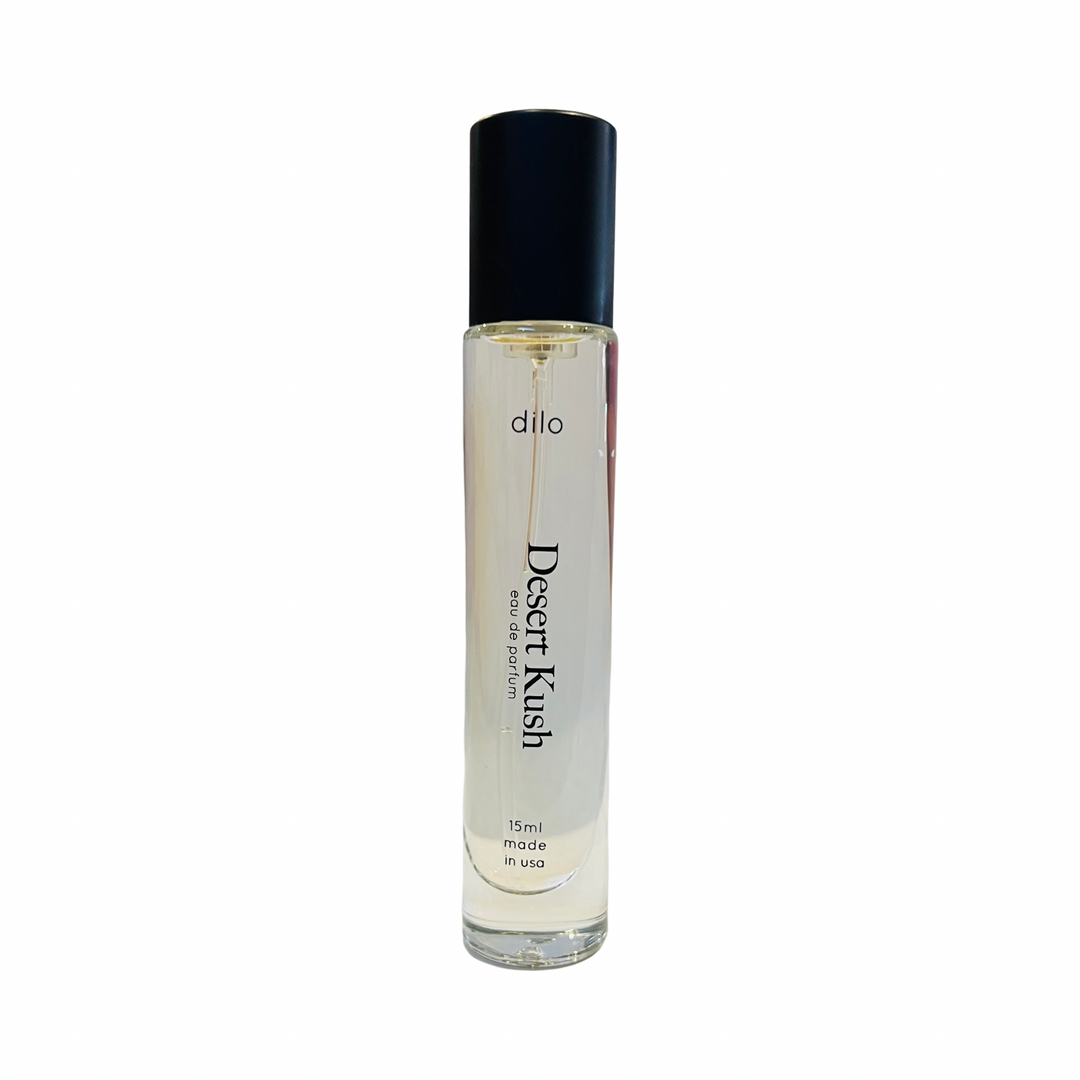 A unisex 'Desert Kush' eau de parfum bottle by Dilo, featuring a clear glass container with a black cap