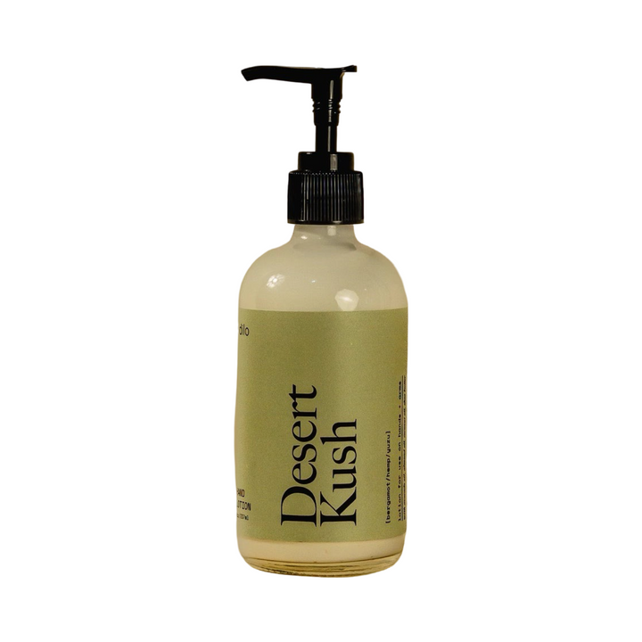 8 oz clear glass pump bottle of Dilo Desert Kush Hand Lotion with a muted sage green label and bold black typography.