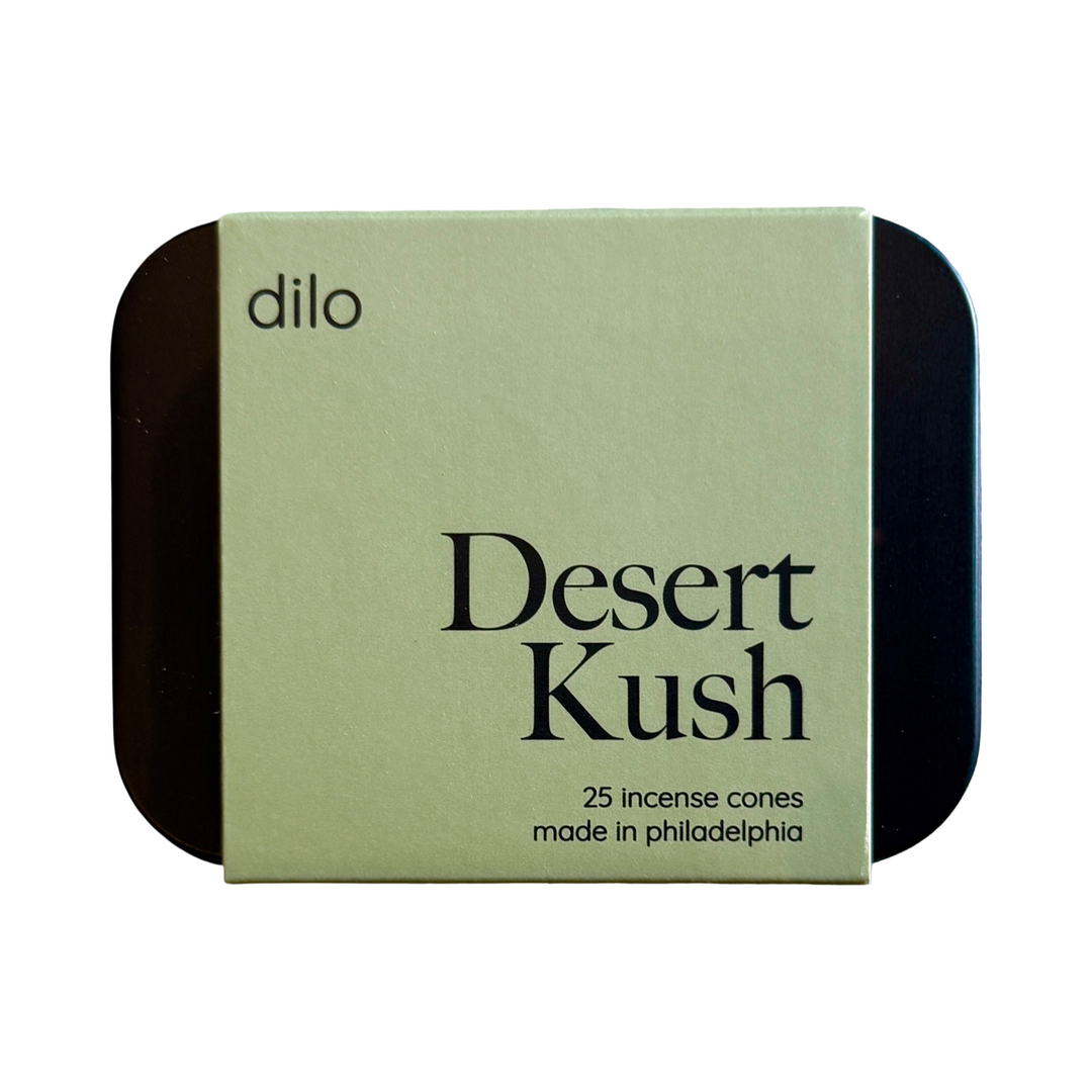 Black rectangular incense container has green branded sleeve with black text.