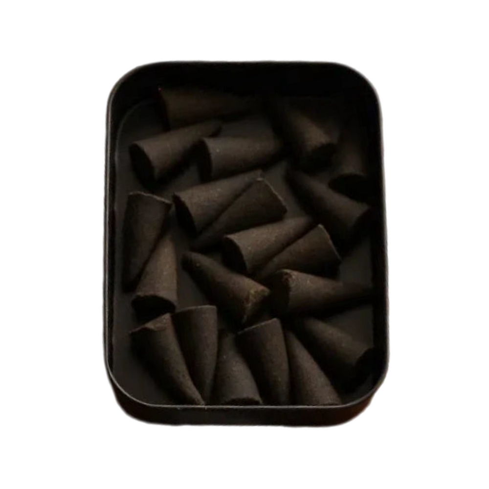 Interior shot of black tin with dark incense cones.