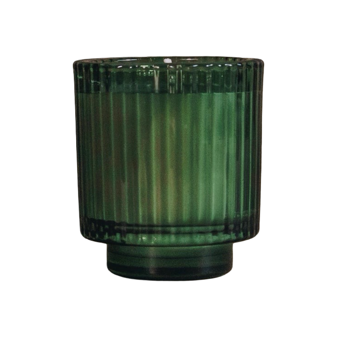 candle in a green ribbed glass vessel with a footed base.
