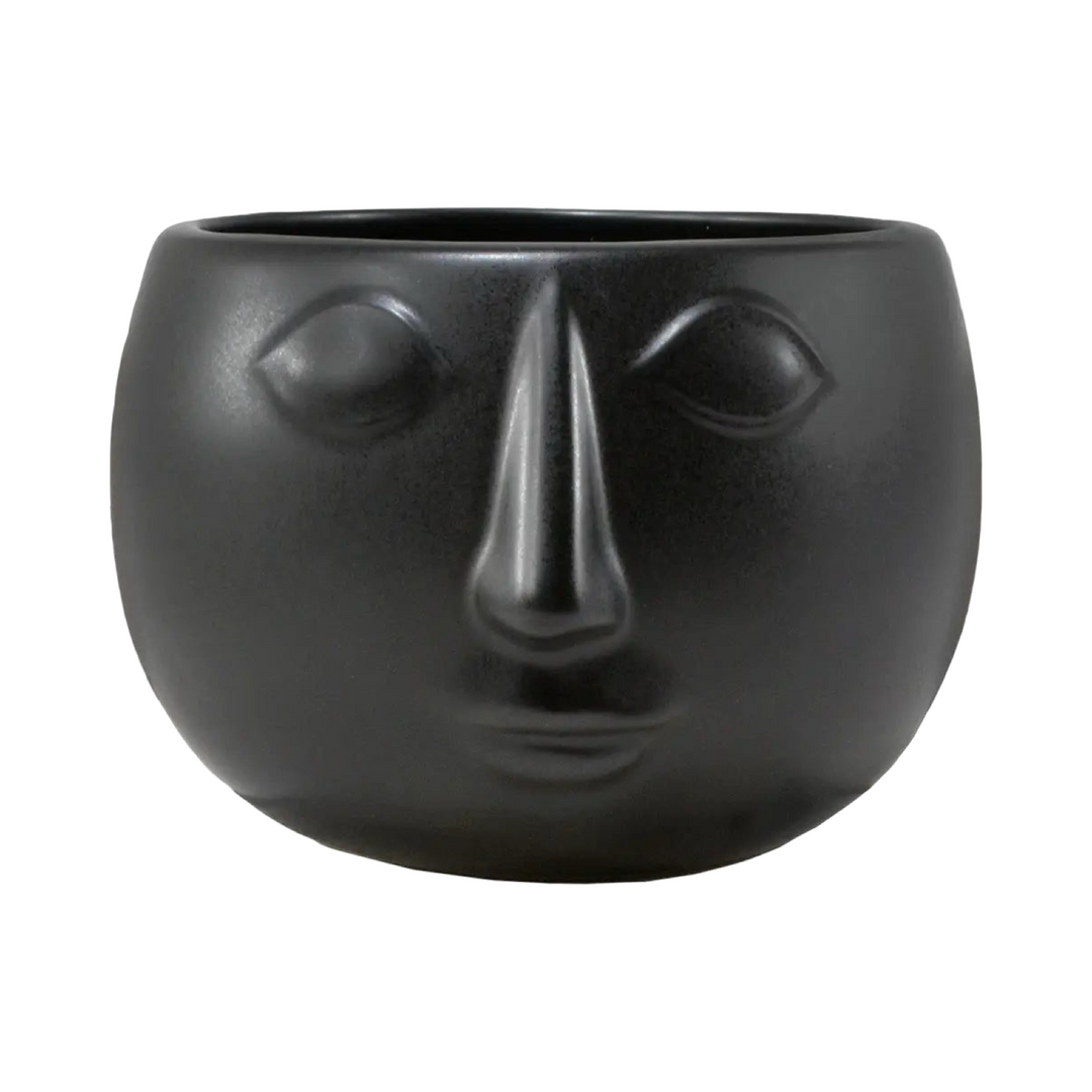 Black face-shaped planter on a white background