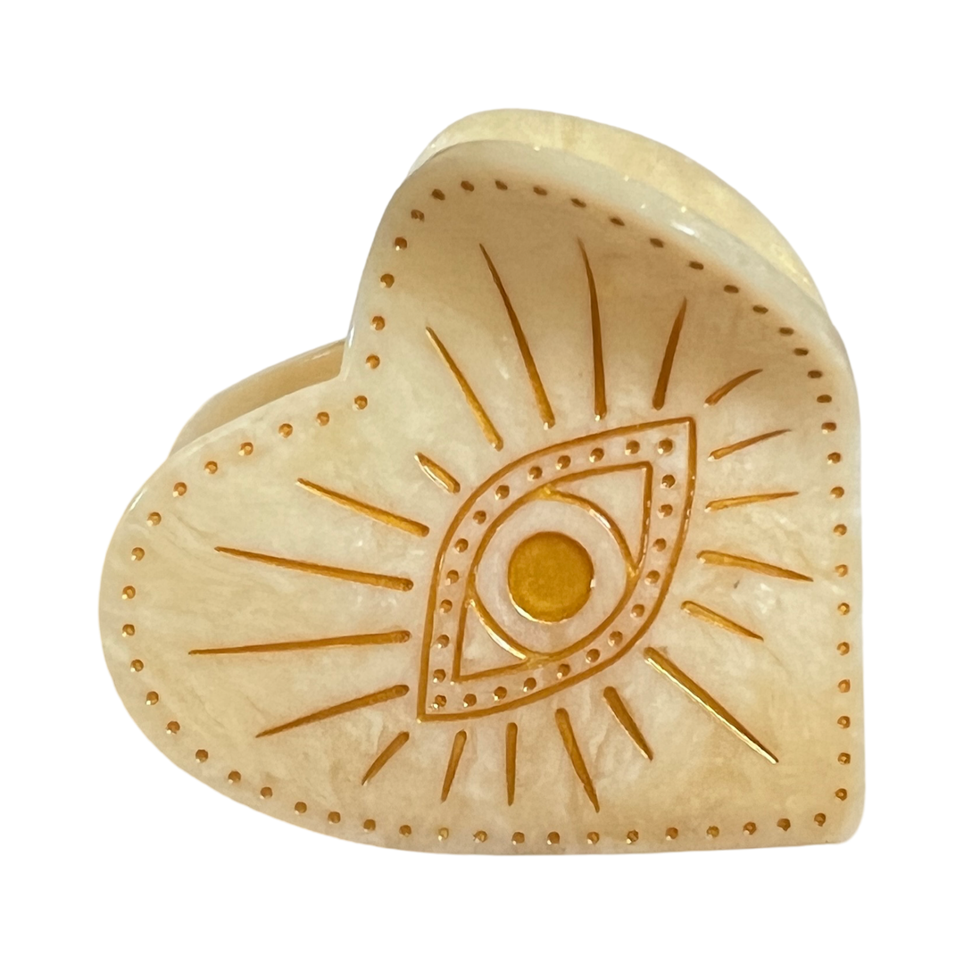 Heart-shaped claw hair clip featuring a celestial eye design with engraved radiant details and golden accents