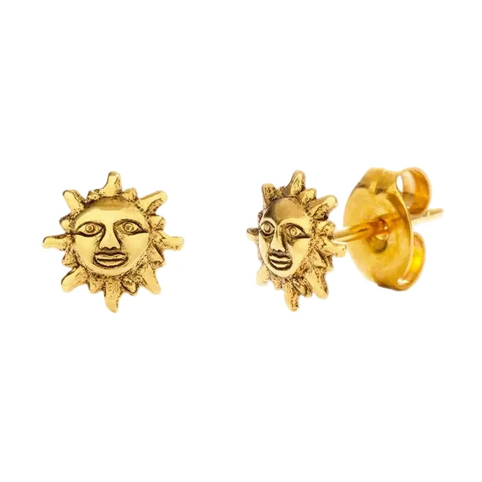 A pair of small gold stud earrings shaped like a sun with a detailed human face and radiating rays, finished in a warm antique gold tone with a push-back closure.
