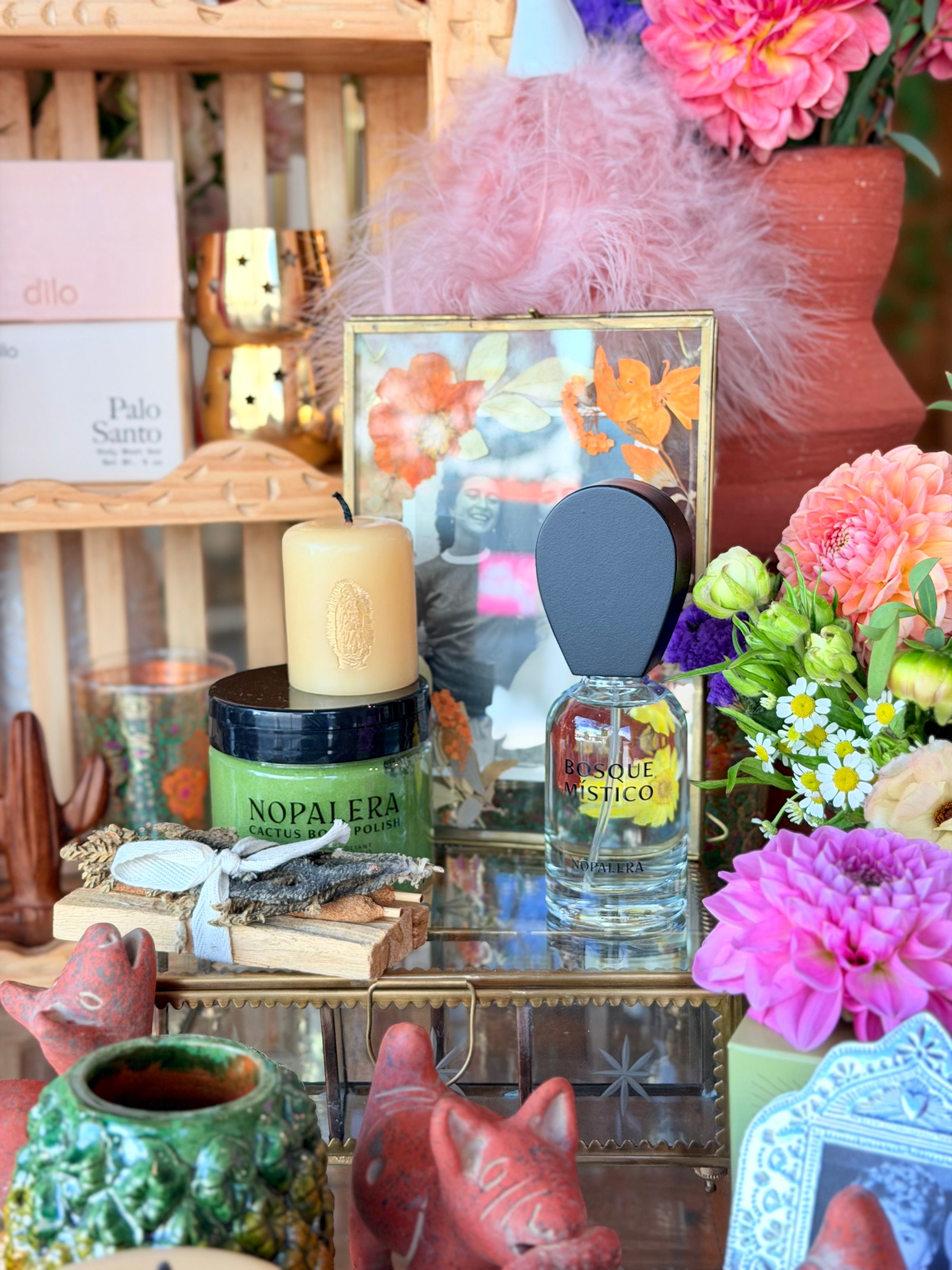 A styled product display featuring a clear glass Nopalera perfume bottle