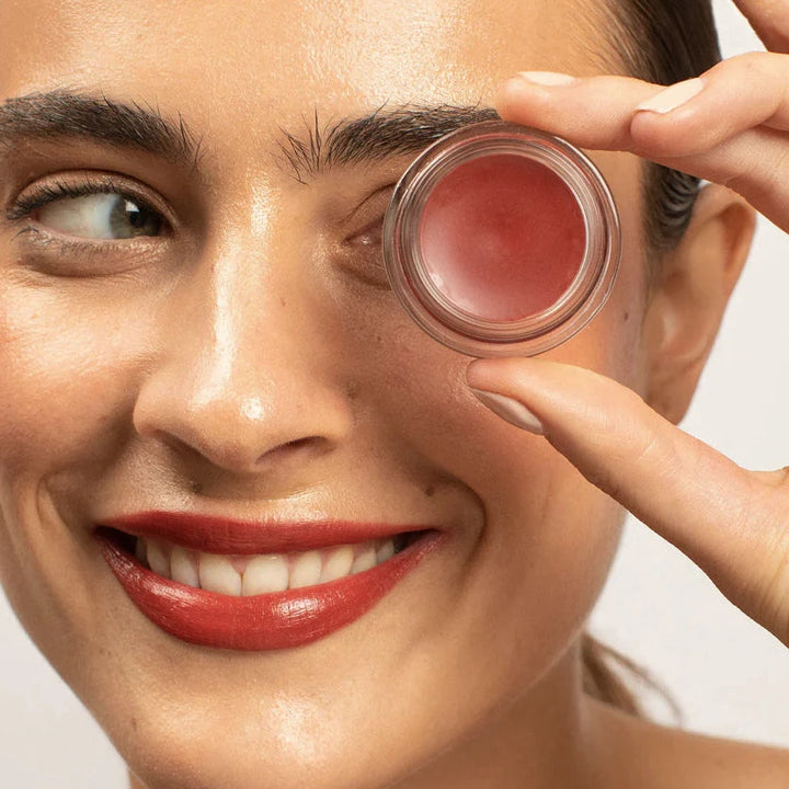 woman holding the color pot to her eye ans smiling