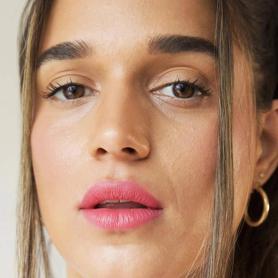 a close up of a woman's face wearing pink lip stick