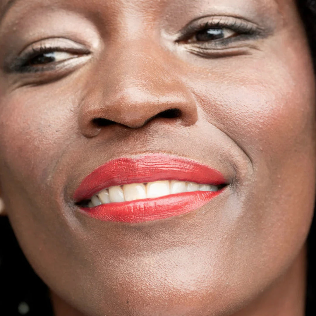 a close up of a woman's face wearing red lip stick