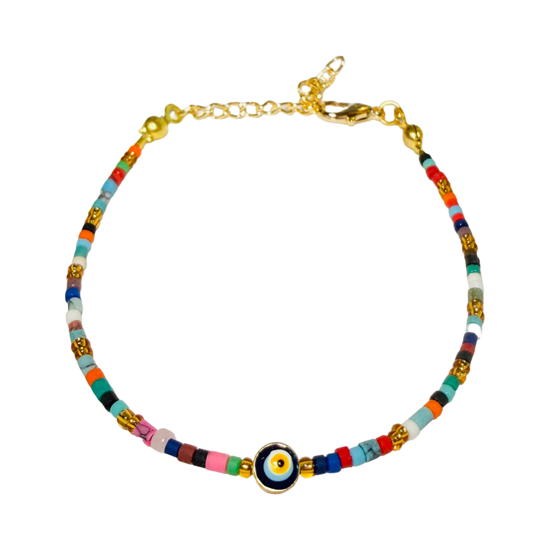 A delicate multicolor seed bead bracelet with a gold evil eye charm centerpiece and a gold lobster clasp closure.