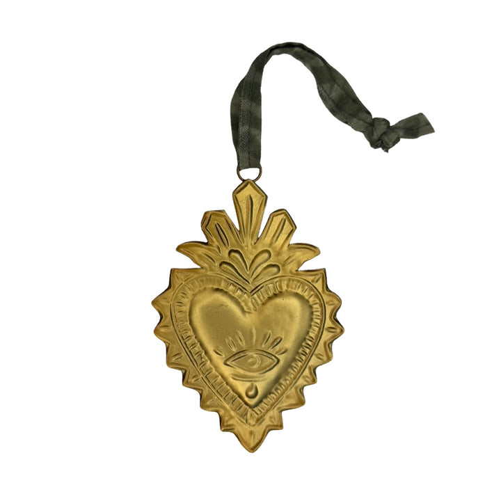 Gold Sacred heart ornament features ornate embossed eye design and has a green ribbon hanger.
