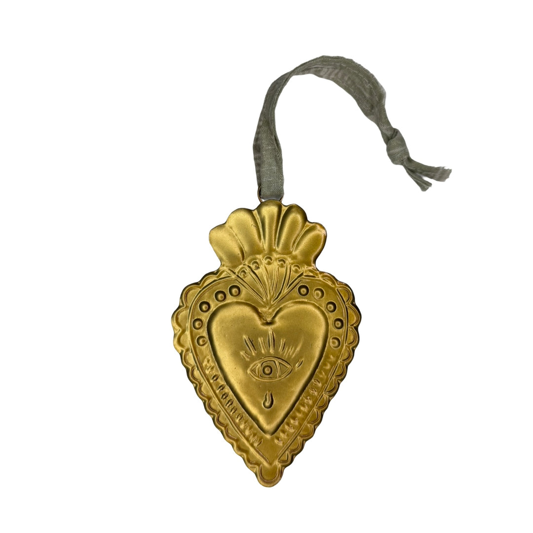 Gold ornament features sacred heart with eye embossed design and has a green ribbon hanger at the top.