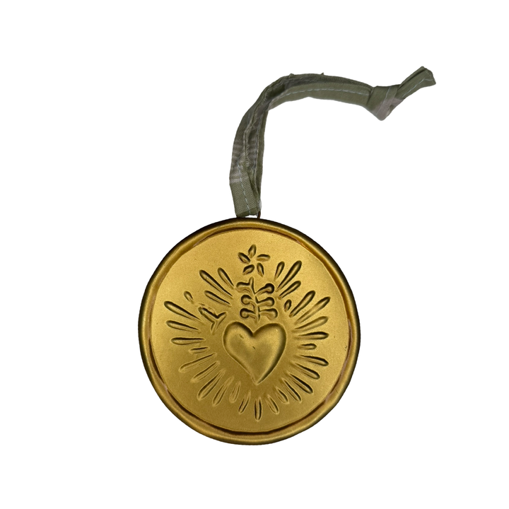 Gold medallion with green ribbon hanger features a radiant heart design.