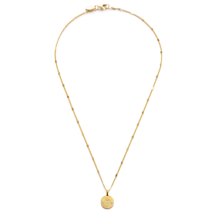A small round gold coin pendant featuring an engraved evil eye with turquoise enamel dot accents, hung on a delicate mixed gold chain with flat bar and curb link details.