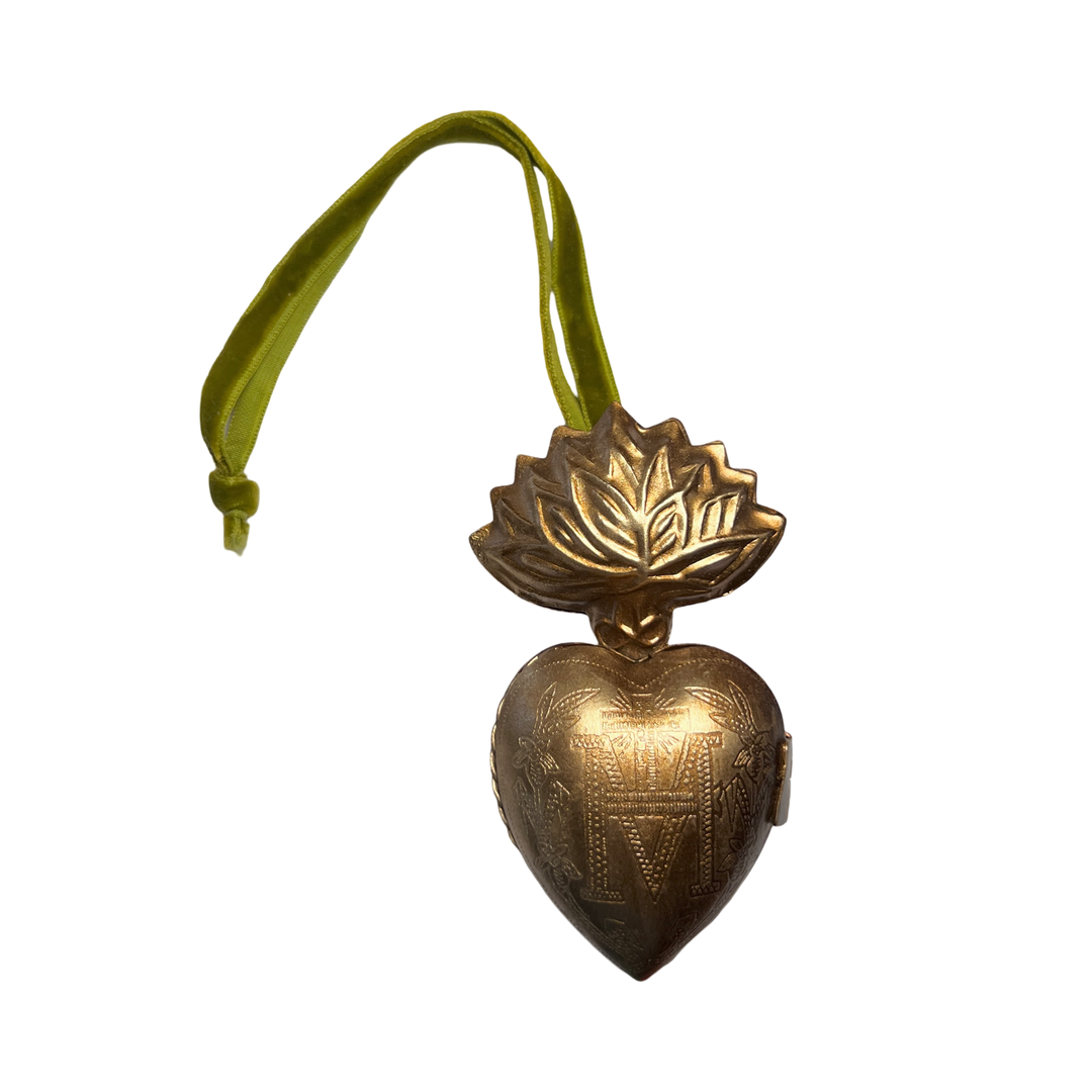 brass heart locket featuring an engraved design with a green velvet hanging loop