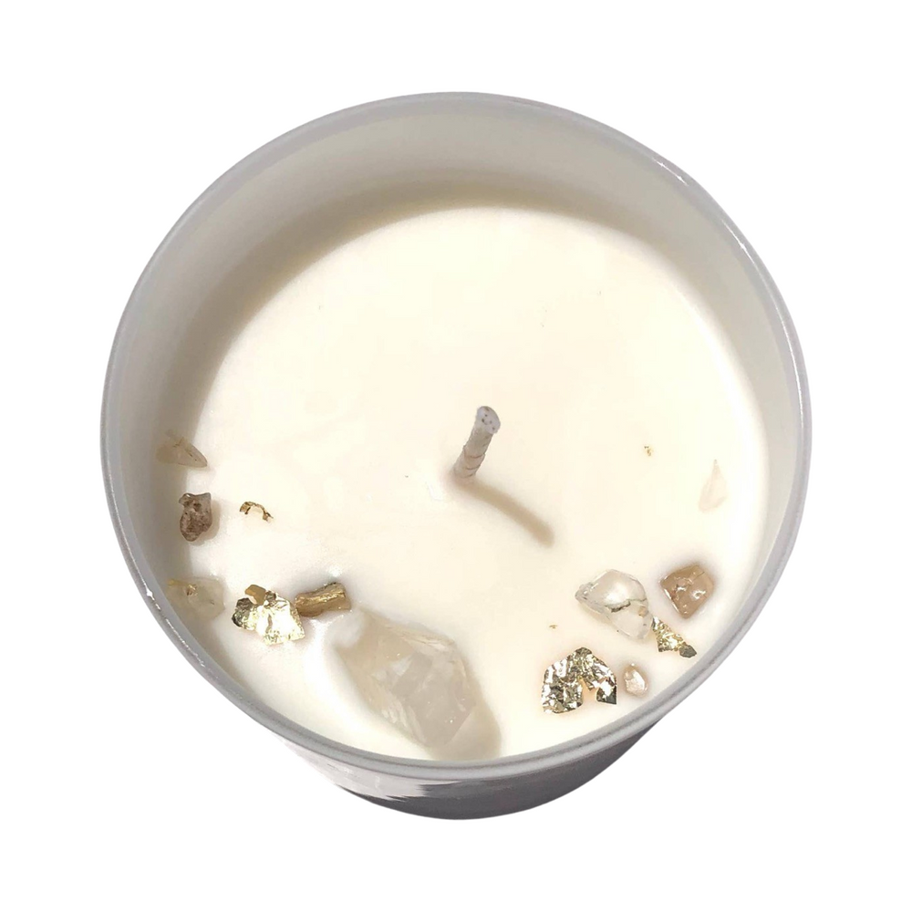 top view of a white candle with crystals and gold flakes