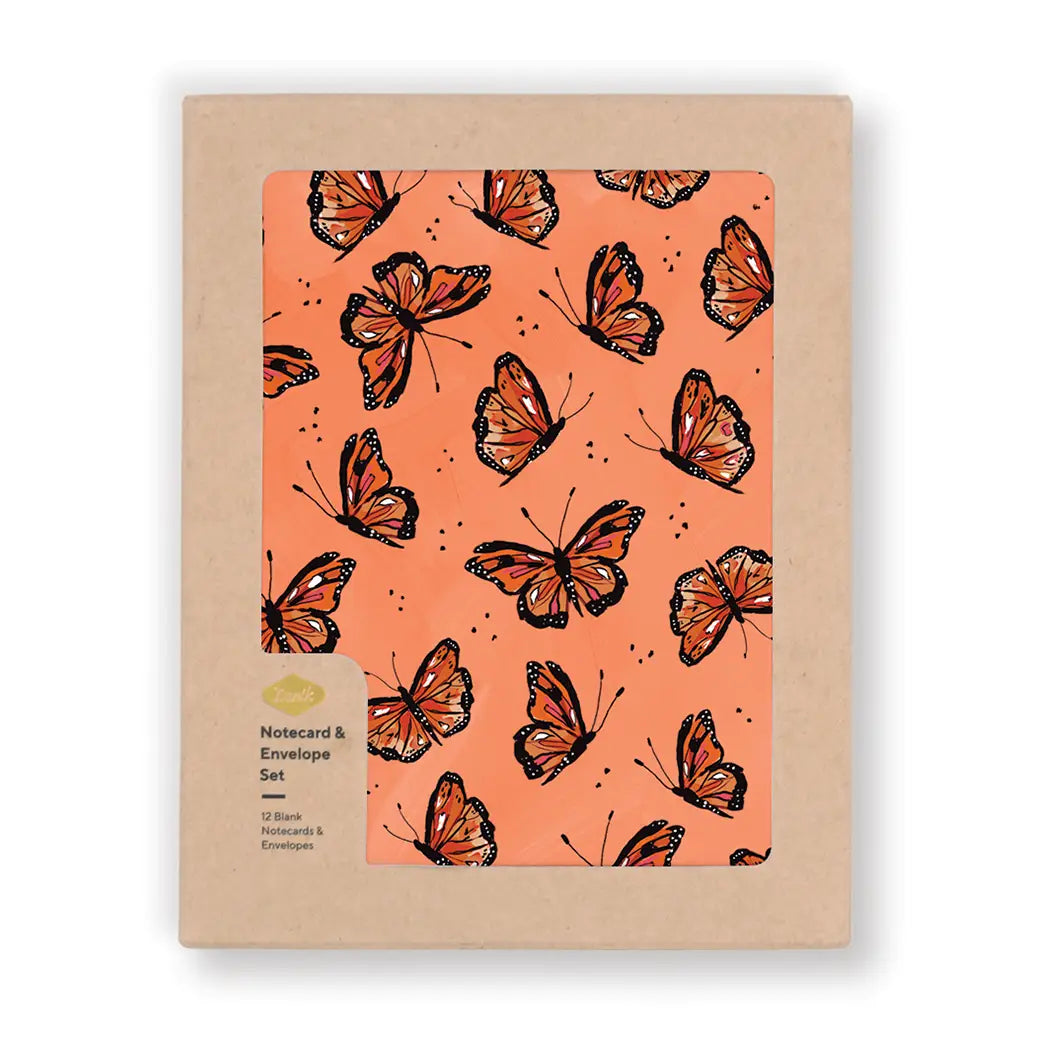 Kraft boxed set of notecards showing a coral card covered in monarch butterflies; label reads “Notecard & Envelope Set — 12 Blank Notecards & Envelopes.”