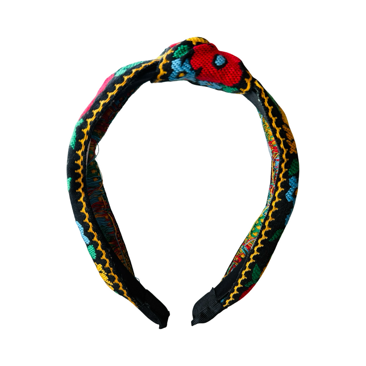 front view of a black headband with a bold colorful floral design in yellow, red, blue and green.