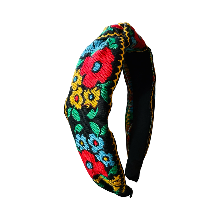 Black headband with a bold colorful floral design in yellow, red, blue and green.