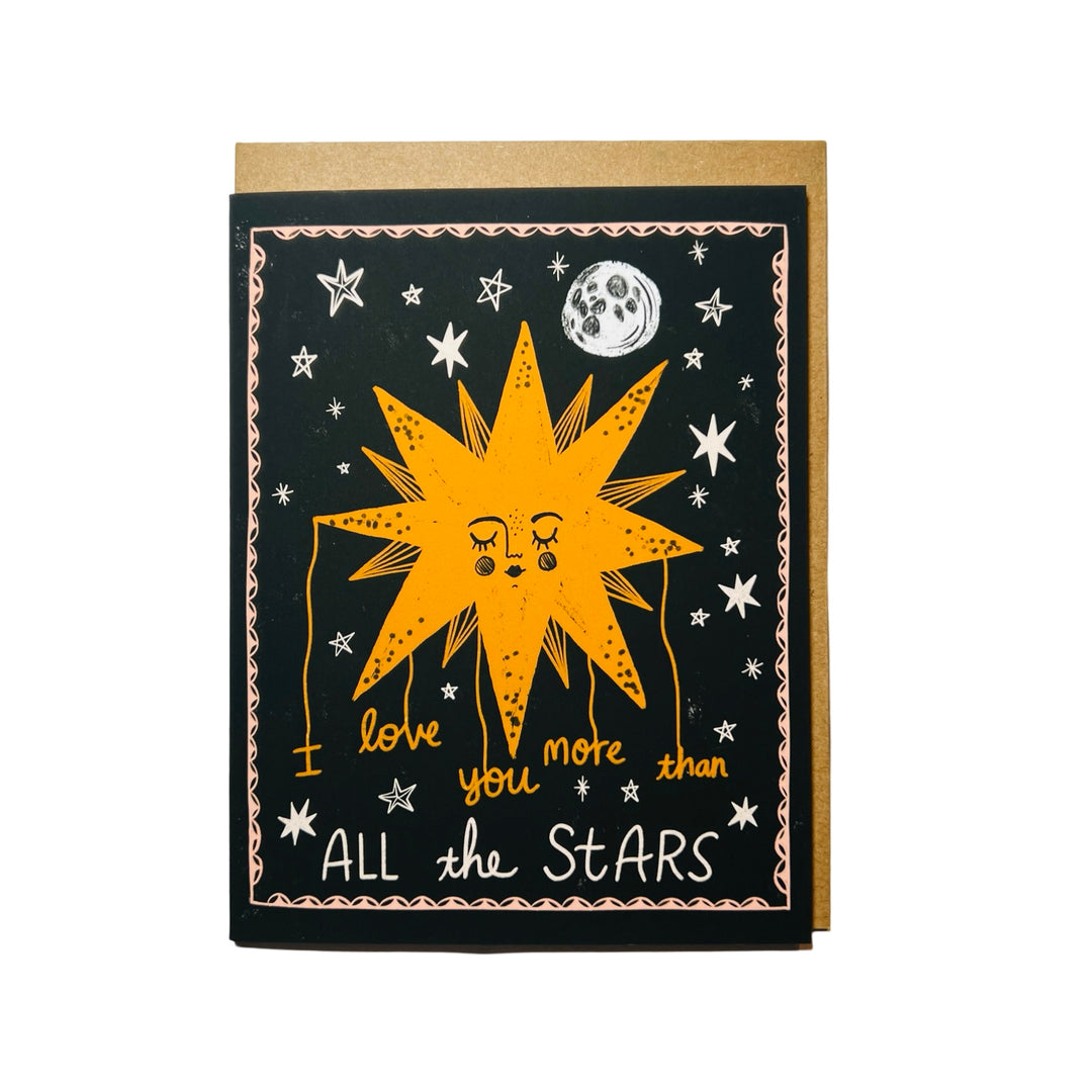 A greeting card with a whimsical star illustration, moon, and the text "I Love You More Than All the Stars," accompanied by a kraft envelope