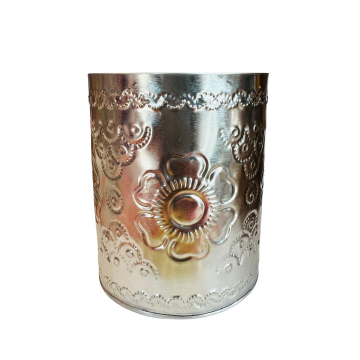 round tin canister featuring a hammered tin floral design