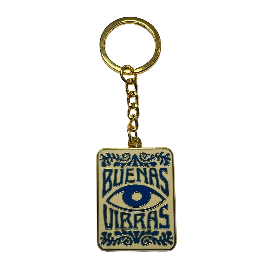 cream rectangle enamel keychain with an image of an eye and the phrase Buenas Vibras in blue.