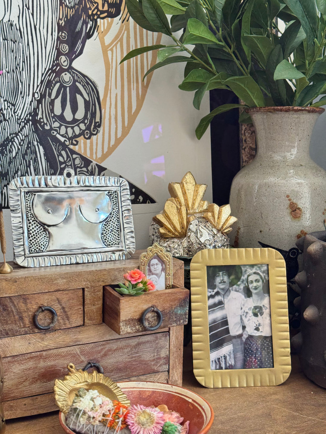 Decorative table with vintage items including a wooden box, metal tray, and framed photos.