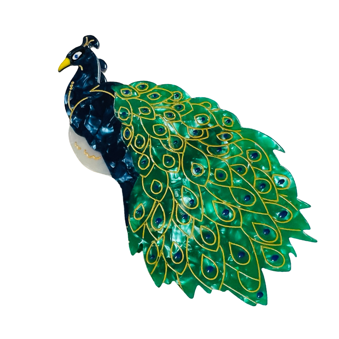 Hand-painted peacock hair claw clip with blue body and shimmering green and gold tail feathers.