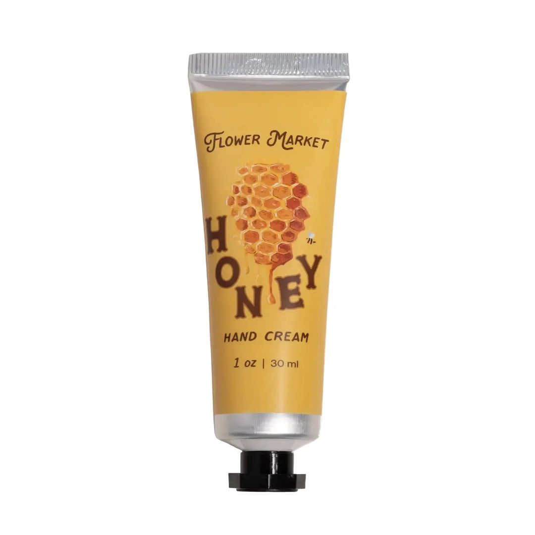 A yellow 1oz tube of Honey Hand Cream by Flower Market, featuring an illustrated honeycomb and bee design.