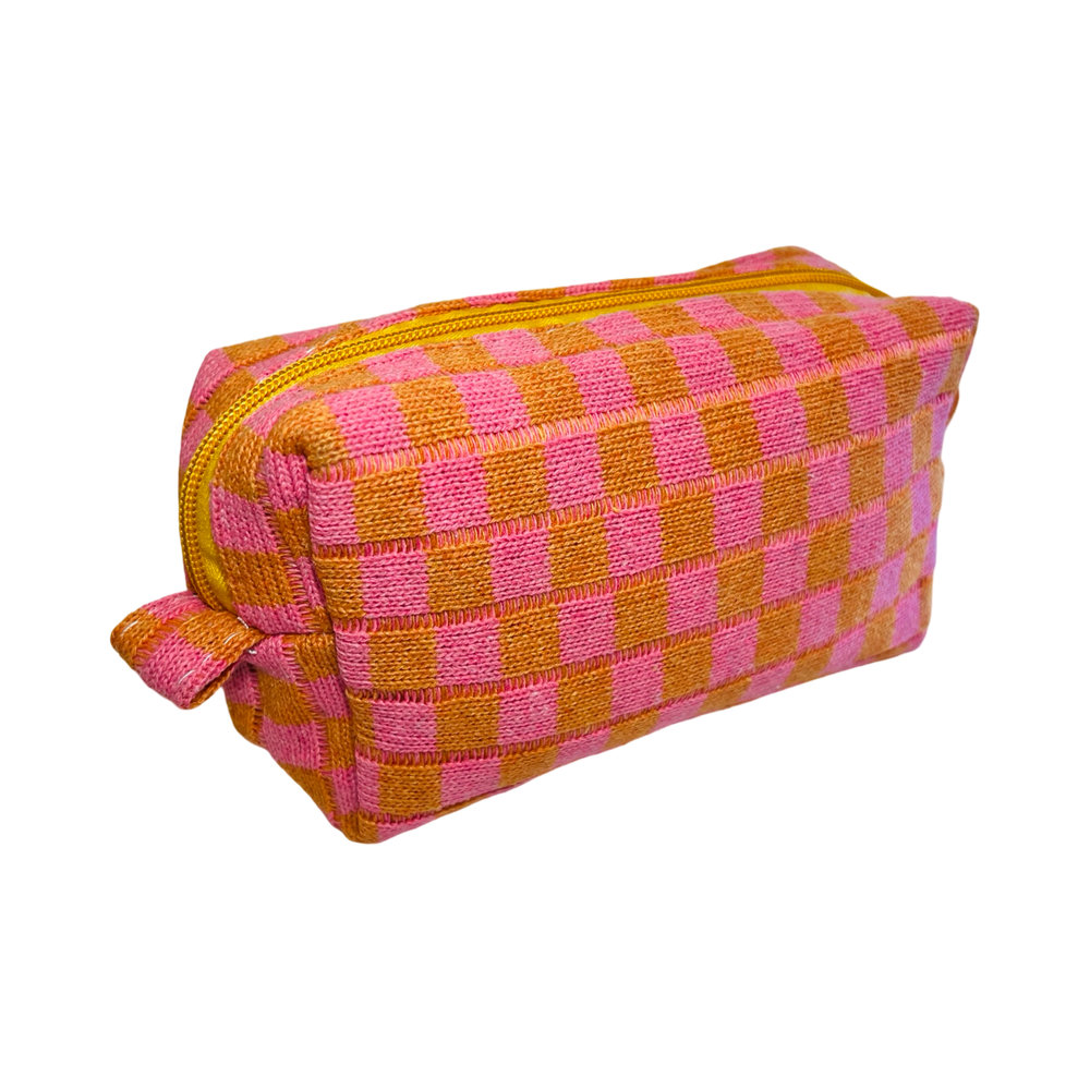 side view of a rectangle cosmetic bag with a orange and pink checkered design