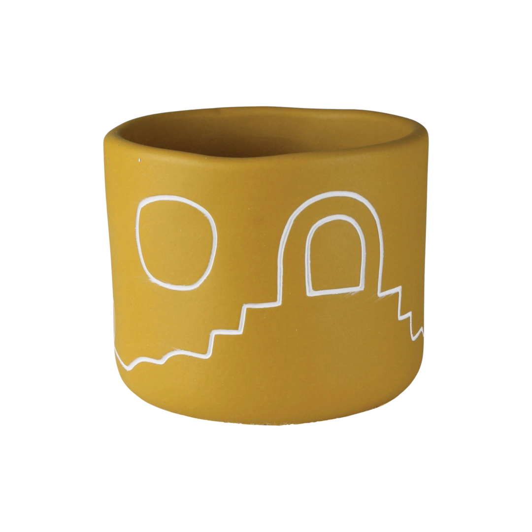 golden yellow cement cachepot with a desert landscape design in white.