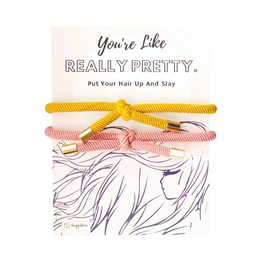 hair tie set features two elegant corded ties in yellow and soft pink, each accented with gold metal tips on a white branded backing.