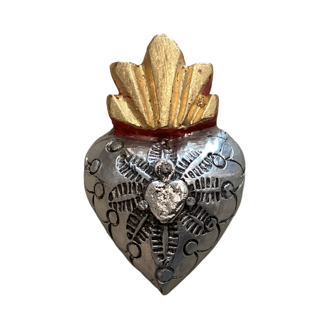 A handcrafted Milagro Wooden Heart with silver-toned metal detailing, an embossed sacred heart design, and a gold-painted flame at the top.