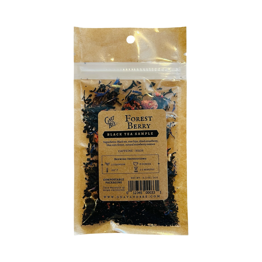 A compostable pouch of Gnat and Bee's "Forest Berry" Black Tea Sample, featuring a blend of black tea, rose hips, dried strawberries, blue cornflower, and natural strawberry essence. The kraft paper label includes brewing instructions and indicates high caffeine content.