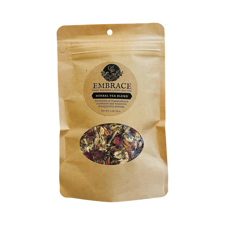 A kraft paper pouch of Gnat and Bee's "Embrace" Hand-Blended Loose Leaf Tea, featuring a clear window showing the herbal tea blend inside. The label describes it as a soothing and harmonious blend that supports the nervous and digestive systems.